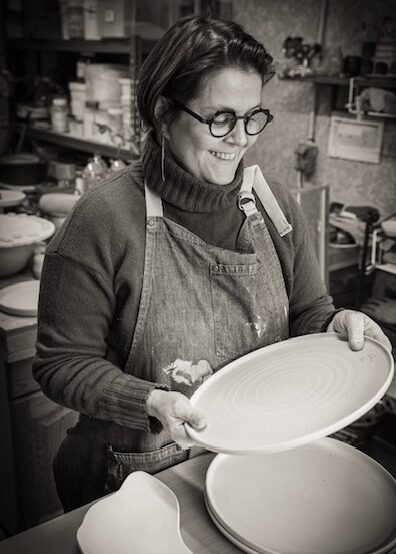 La céramiste défourne le four de l'atelier.
